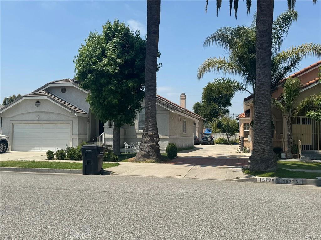 15727 Virginia Ave, Paramount, CA 90723 - view of front of house featuring concrete driveway, stucco siding, and an attached garage