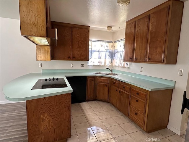1624 Forane St, Barstow, CA 92311 - kitchen with a peninsula, black appliances, light countertops, brown cabinetry, and a textured ceiling