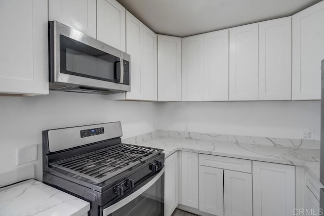 734738 Grand Ave, Spring Valley, CA 91977 - kitchen with stainless steel appliances, white cabinets, and light stone counters