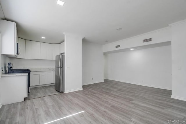 734738 Grand Ave, Spring Valley, CA 91977 - kitchen featuring appliances with stainless steel finishes, open floor plan, light countertops, light wood finished floors, and white cabinetry