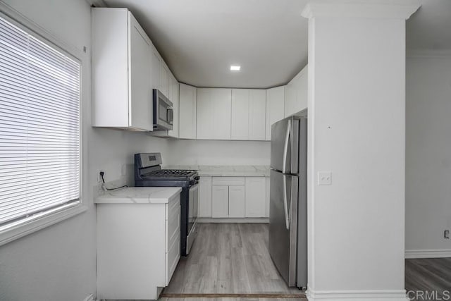734738 Grand Ave, Spring Valley, CA 91977 - kitchen with appliances with stainless steel finishes, light wood-style flooring, white cabinets, and light stone countertops
