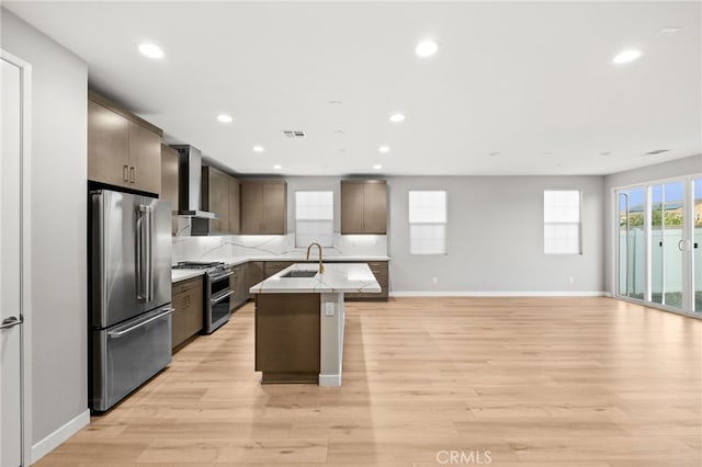 431 Daniella Way, Perris, CA 92570 - kitchen with appliances with stainless steel finishes, wall chimney range hood, a center island with sink, light countertops, and recessed lighting