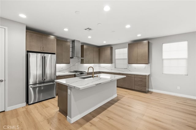 431 Daniella Way, Perris, CA 92570 - kitchen featuring stainless steel appliances, wall chimney range hood, light wood-style floors, recessed lighting, and a center island with sink