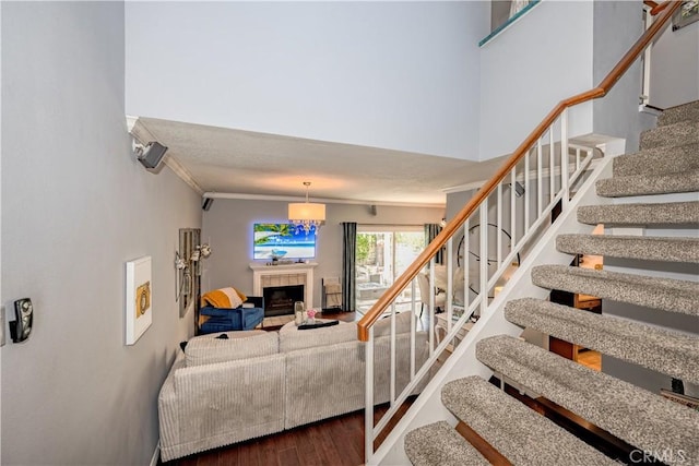 22943 Banyan Pl Unit 306, Saugus, CA 91390 - staircase featuring wood finished floors, a tile fireplace, and ornamental molding