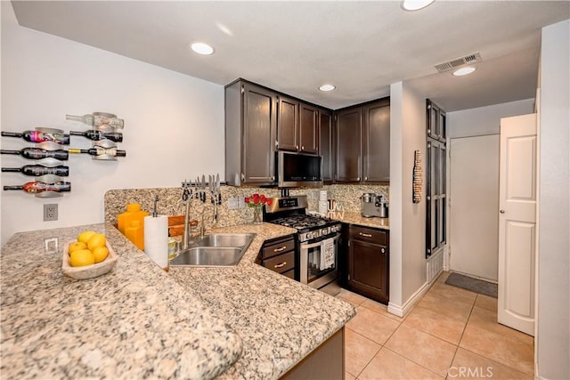 22943 Banyan Pl Unit 306, Saugus, CA 91390 - kitchen with stainless steel appliances, light tile patterned floors, tasteful backsplash, dark brown cabinetry, and recessed lighting