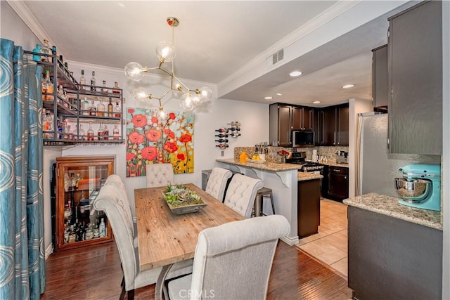 22943 Banyan Pl Unit 306, Saugus, CA 91390 - dining space featuring ornamental molding, a chandelier, and light wood-style flooring