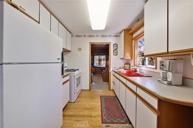 26314 Jacqueline Rd, Twin Peaks, CA 92391 - kitchen with white appliances, light wood finished floors, white cabinetry, and light countertops