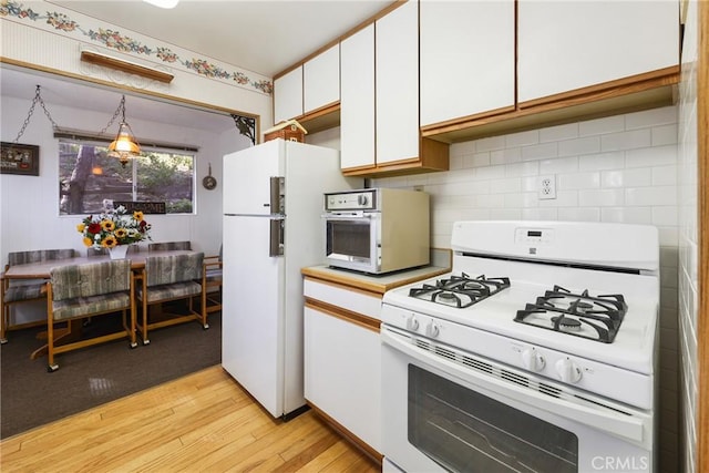 26314 Jacqueline Rd, Twin Peaks, CA 92391 - kitchen featuring white appliances, light wood-style flooring, white cabinetry, backsplash, and light countertops