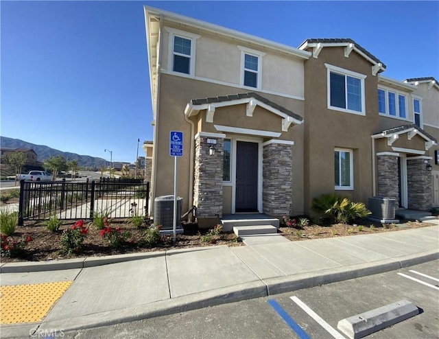 16620 Wyndham Ln Unit 11, Fontana, CA 92336 - view of front of house featuring stucco siding, stone siding, and a mountain view