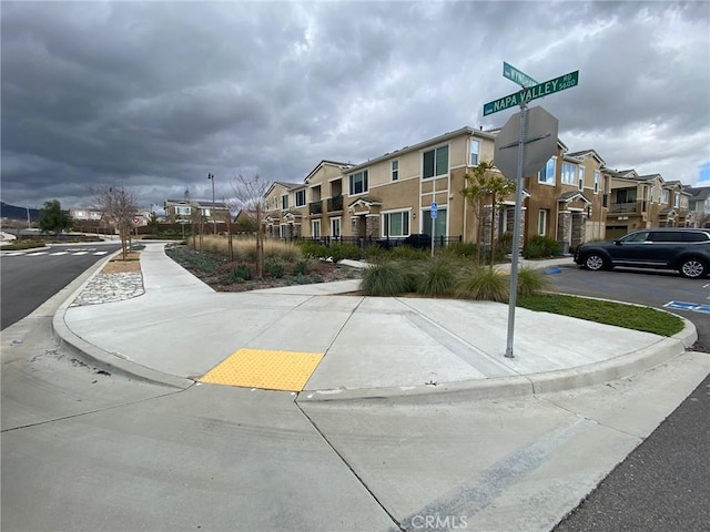 16620 Wyndham Ln Unit 11, Fontana, CA 92336 - view of asphalt road featuring a residential view, sidewalks, and curbs