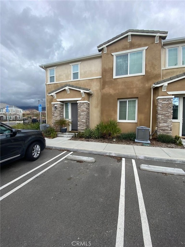 16620 Wyndham Ln Unit 11, Fontana, CA 92336 - townhome / multi-family property featuring stucco siding, uncovered parking, and stone siding