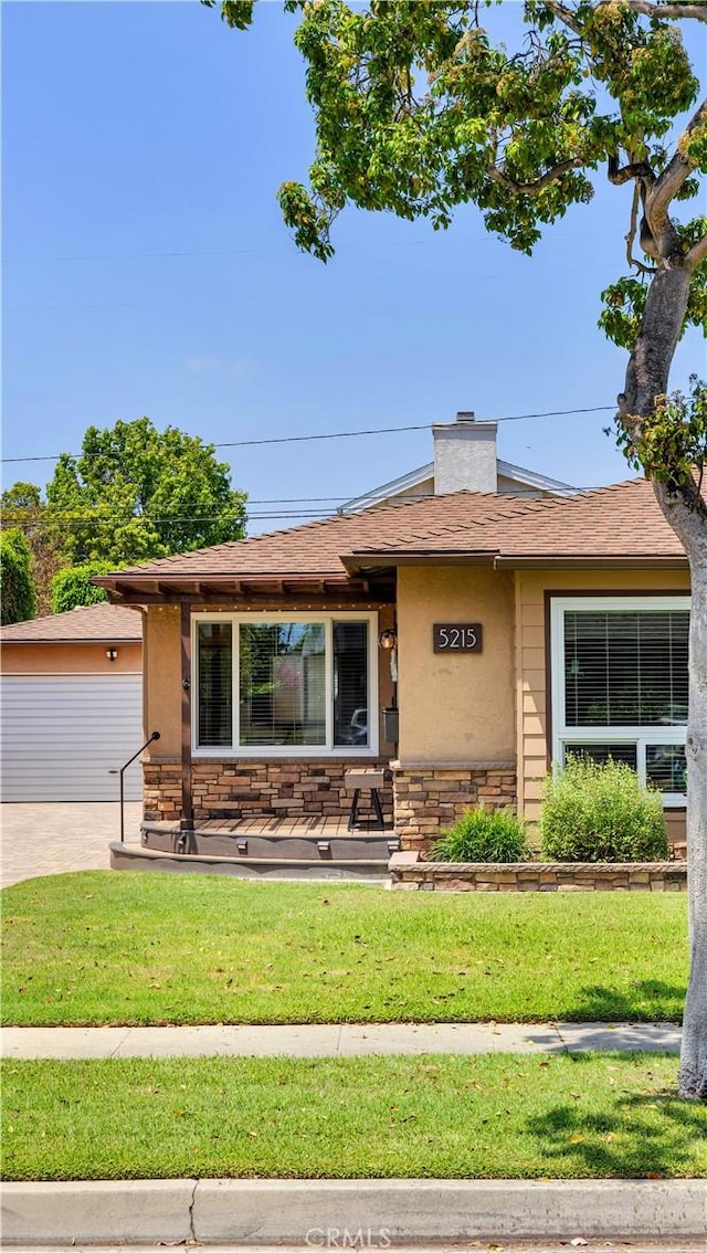 5215 E Monlaco Rd, Long Beach, CA 90808 - view of front of home with a front lawn, stone siding, a garage, and stucco siding