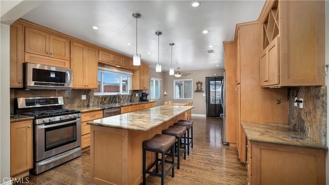 5215 E Monlaco Rd, Long Beach, CA 90808 - kitchen featuring appliances with stainless steel finishes, a kitchen island, light wood-type flooring, backsplash, and recessed lighting