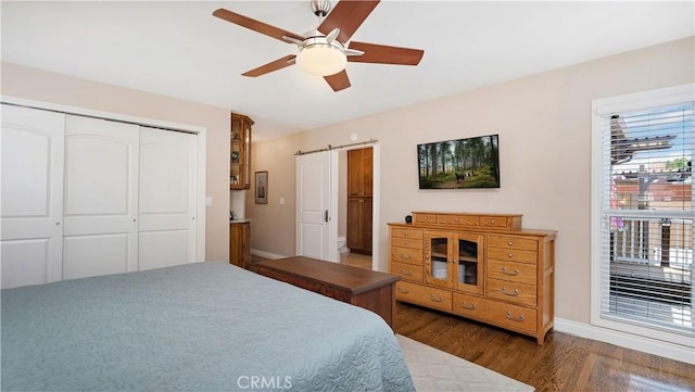 5215 E Monlaco Rd, Long Beach, CA 90808 - bedroom with wood finished floors, a closet, a ceiling fan, and a barn door