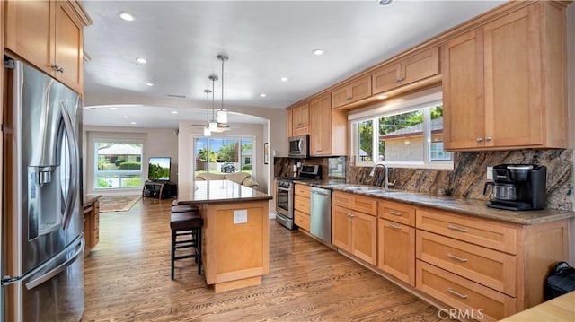 5215 E Monlaco Rd, Long Beach, CA 90808 - kitchen with stainless steel appliances, recessed lighting, light wood-style flooring, light stone counters, and tasteful backsplash