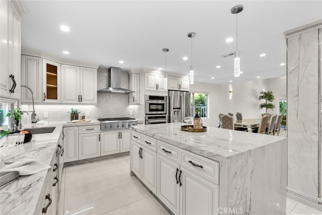 6355 Yolanda Ave, Tarzana, CA 91335 - kitchen with appliances with stainless steel finishes, wall chimney range hood, a center island, tasteful backsplash, and white cabinetry