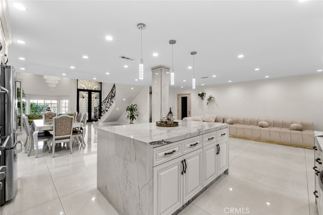 6355 Yolanda Ave, Tarzana, CA 91335 - kitchen featuring open floor plan, light stone countertops, white cabinets, light tile patterned flooring, and decorative light fixtures
