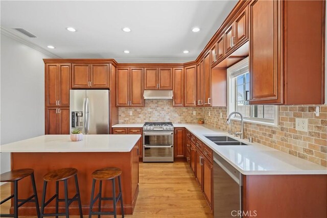 18651 E Weather Rd, Covina, CA 91722 - kitchen featuring stainless steel appliances, under cabinet range hood, a breakfast bar, light wood-type flooring, and crown molding