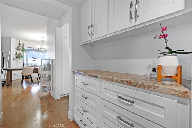 1995 Molino Ave Unit 102, Signal Hill, CA 90755 - kitchen featuring light wood-style floors, white cabinets, a chandelier, and light stone counters