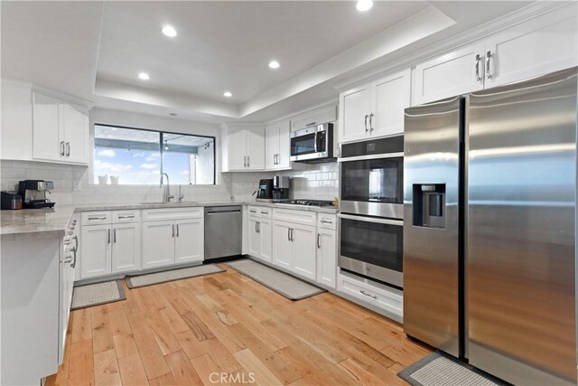 1995 Molino Ave Unit 102, Signal Hill, CA 90755 - kitchen featuring stainless steel appliances, a raised ceiling, light wood-style floors, white cabinetry, and recessed lighting