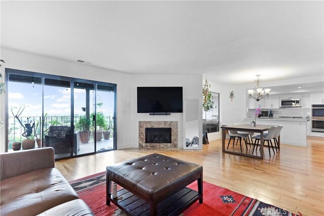 1995 Molino Ave Unit 102, Signal Hill, CA 90755 - living room featuring a chandelier, light wood-style flooring, and a high end fireplace
