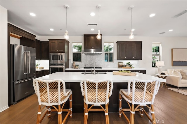 143 Hollow Tree, Irvine, CA 92618 - kitchen with stainless steel appliances, light countertops, dark brown cabinets, tasteful backsplash, and wood finished floors