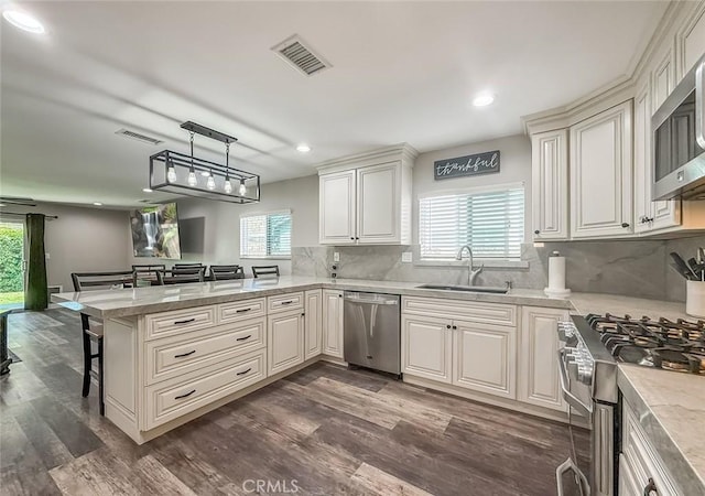 2288 Marilyn St, Simi Valley, CA 93065 - kitchen with stainless steel appliances, a peninsula, a kitchen bar, recessed lighting, and dark wood-style floors