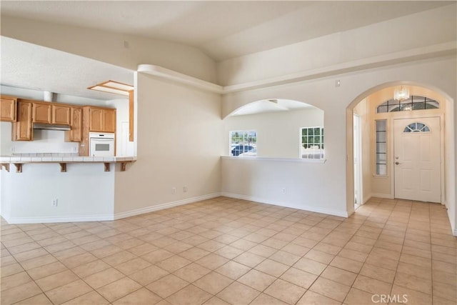 11471 Azure View Rd, Pinon Hills, CA 92372 - unfurnished living room with lofted ceiling, arched walkways, and light tile patterned floors