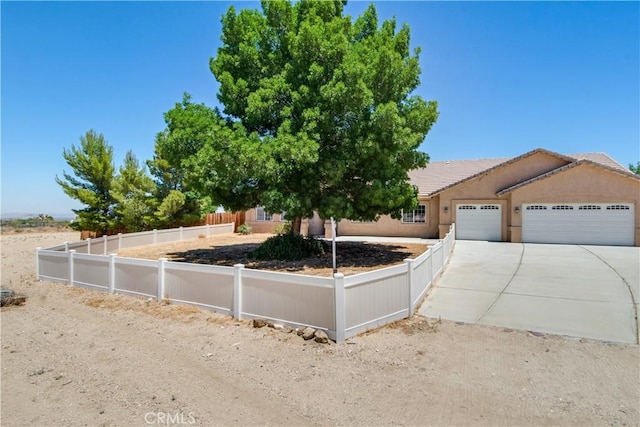 11471 Azure View Rd, Pinon Hills, CA 92372 - view of front facade featuring an attached garage, driveway, a fenced front yard, and stucco siding