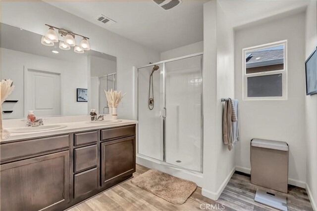 2146 N Rinaldi Ct, Visalia, CA 93291 - full bathroom featuring double vanity, a stall shower, and wood finished floors