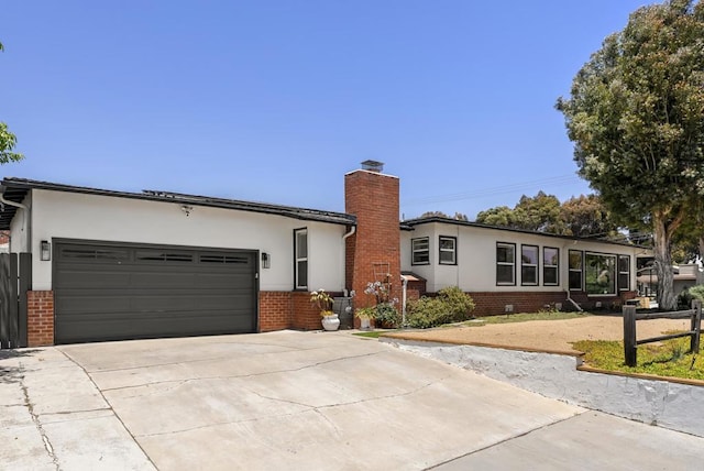 205 C St, Chula Vista, CA 91910 - ranch-style home with stucco siding, brick siding, a chimney, concrete driveway, and a garage