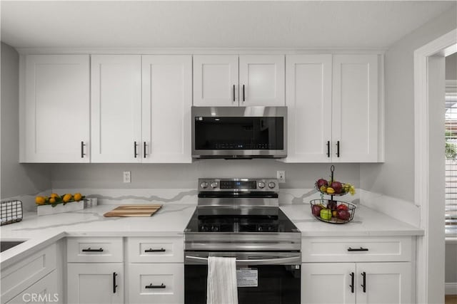 2433 Carlsbad Cir, Hemet, CA 92545 - kitchen featuring appliances with stainless steel finishes, white cabinetry, and light stone countertops