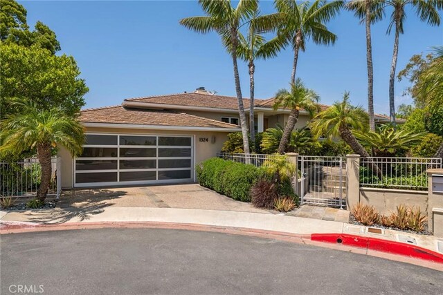 1324 Pitcairn Pl, Laguna Beach, CA 92651 - view of front facade with stucco siding, concrete driveway, a garage, and a chimney