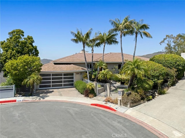 1324 Pitcairn Pl, Laguna Beach, CA 92651 - view of front of property with an attached garage, stucco siding, driveway, and a gate