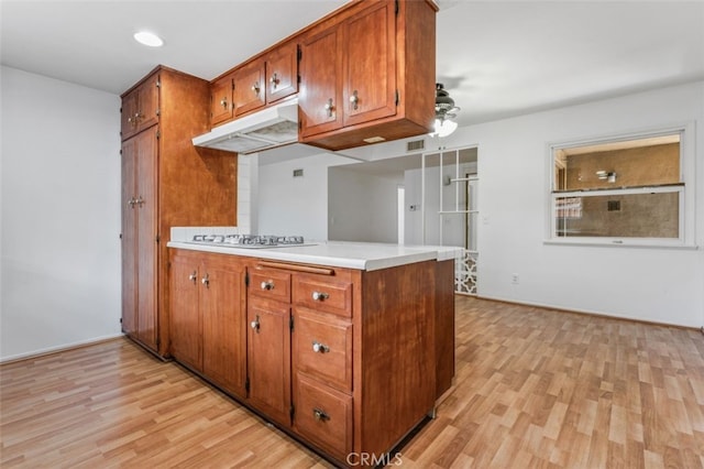 9726 Kimberly Ave, Montclair, CA 91763 - kitchen with gas stovetop, under cabinet range hood, brown cabinets, and light wood-style floors