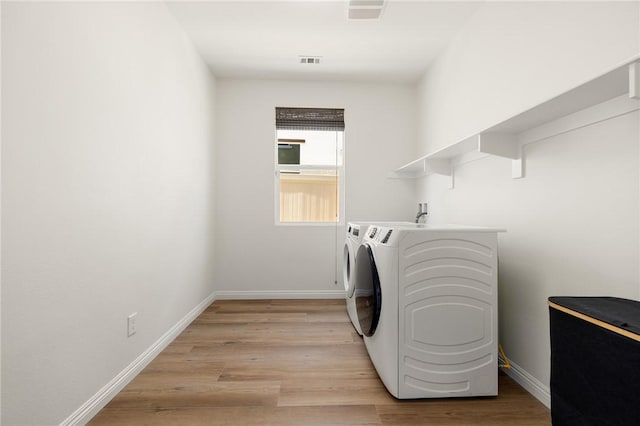 30644 Stage Coach Rd, Menifee, CA 92584 - washroom with washer and clothes dryer and light wood-style flooring