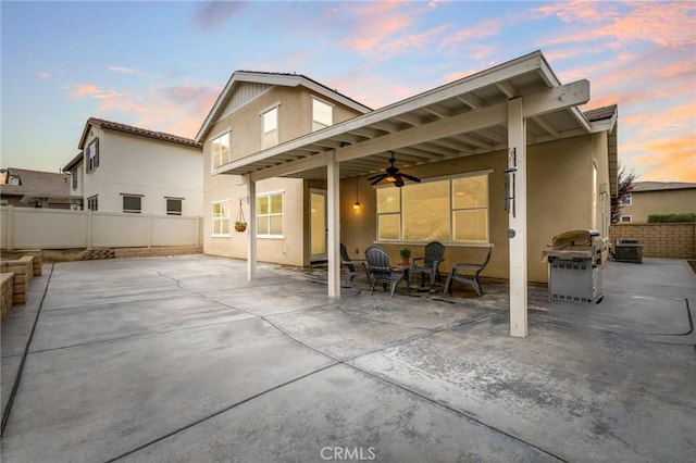30644 Stage Coach Rd, Menifee, CA 92584 - back of house at dusk with a ceiling fan, stucco siding, a fenced backyard, and a patio