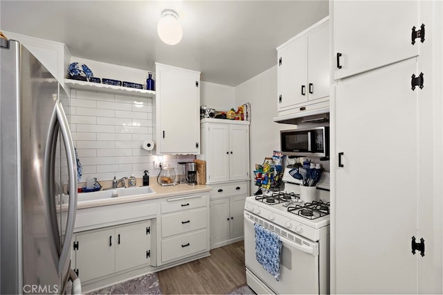 4292 Howard Ave, Los Alamitos, CA 90720 - kitchen with appliances with stainless steel finishes, white cabinets, light wood-style floors, light countertops, and backsplash