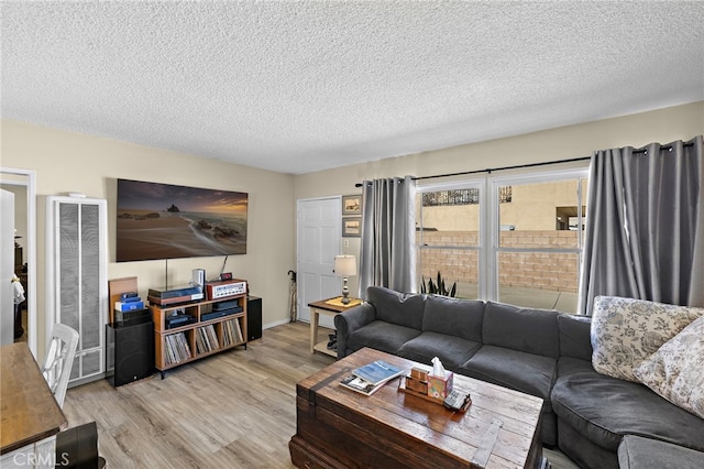 4292 Howard Ave, Los Alamitos, CA 90720 - living area featuring a heating unit, light wood-style floors, and a textured ceiling