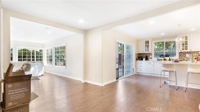 3375 Fuchsia, Costa Mesa, CA 92626 - kitchen featuring open floor plan, light wood finished floors, decorative backsplash, a breakfast bar area, and glass insert cabinets