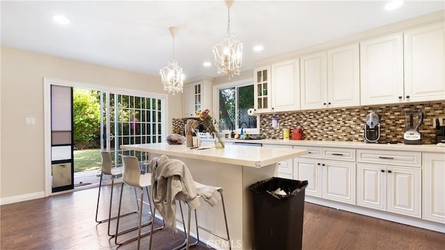 3375 Fuchsia, Costa Mesa, CA 92626 - kitchen with a chandelier, a breakfast bar, backsplash, dark wood-style floors, and light countertops