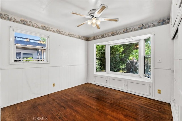 1920 Faust Ave, Long Beach, CA 90815 - empty room with dark wood-style flooring, a ceiling fan, healthy amount of natural light, and wainscoting