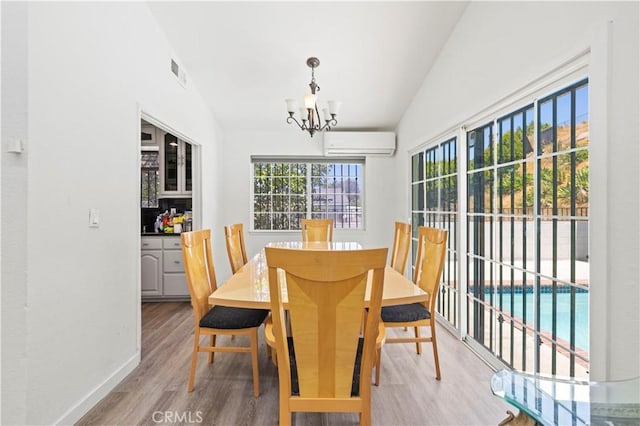 12616 Terra Bella St, Pacoima, CA 91331 - dining space featuring a wall unit AC, wood finished floors, and a chandelier