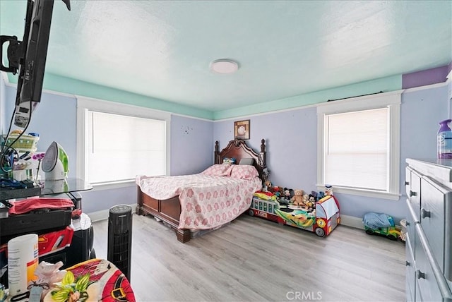 1665 Arlington Ave, Los Angeles, CA 90019 - bedroom featuring light wood-type flooring and multiple windows