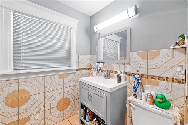 1665 Arlington Ave, Los Angeles, CA 90019 - bathroom featuring vanity, tile walls, a wainscoted wall, and tile patterned floors