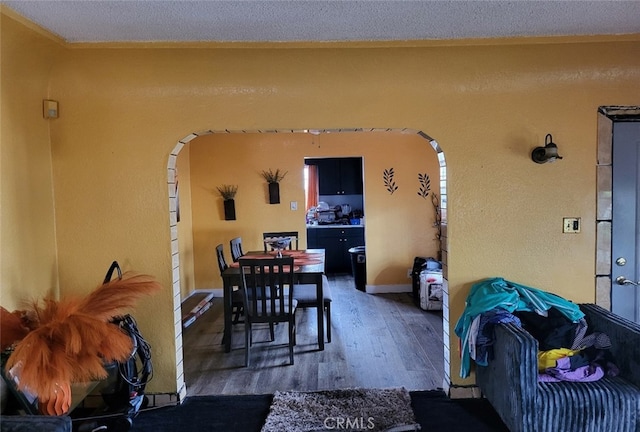 8110 S Denker Ave, Los Angeles, CA 90047 - dining space with arched walkways, wood finished floors, a textured ceiling, and a textured wall