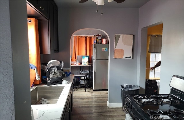 8110 S Denker Ave, Los Angeles, CA 90047 - kitchen with freestanding refrigerator, black gas range oven, ceiling fan, and dark wood finished floors