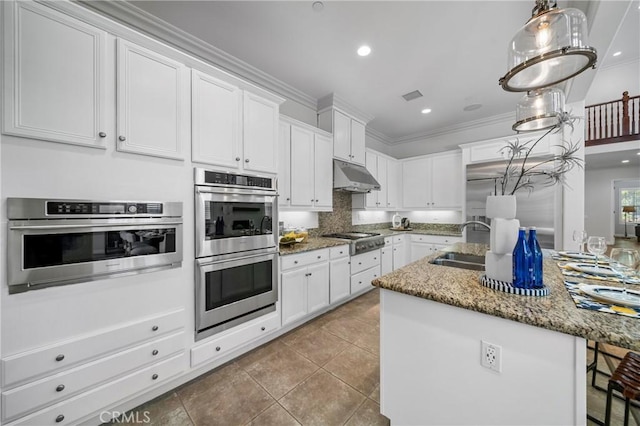 53 Interlude, Irvine, CA 92620 - kitchen featuring stainless steel appliances, under cabinet range hood, white cabinets, light stone countertops, and ornamental molding