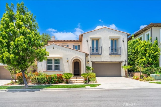 53 Interlude, Irvine, CA 92620 - mediterranean / spanish-style home featuring a balcony, a garage, stucco siding, concrete driveway, and a tile roof
