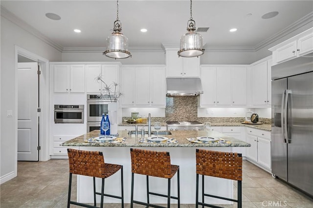 53 Interlude, Irvine, CA 92620 - kitchen with appliances with stainless steel finishes, under cabinet range hood, a kitchen bar, white cabinets, and an island with sink